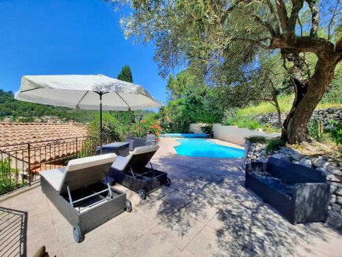 une terrasse avec des chaises et un parasol ainsi qu'une piscine dans l'établissement Villa 