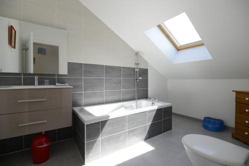 uma casa de banho com um lavatório, um WC e uma clarabóia em Fleur de Lys em Mer