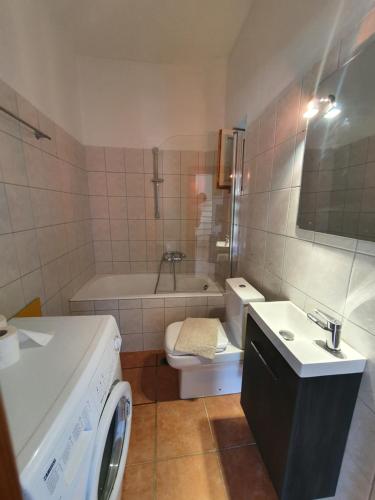 W łazience znajduje się toaleta, umywalka i pralka. w obiekcie Stoupa Mani Tower w mieście Stoupa