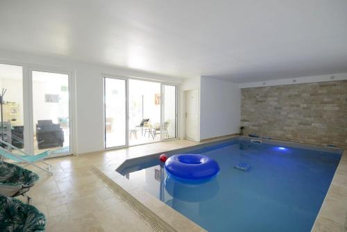 un salon avec une grande piscine bleue dans l'établissement Fleur de Lys, à Mer