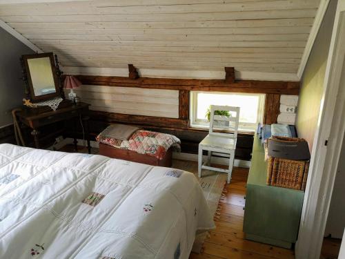 a bedroom with a bed and a desk and a window at Torpet Norra Lundåsen in Fristad