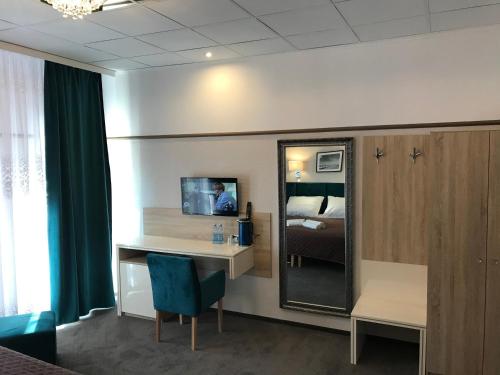 Zimmer mit einem Schreibtisch und einem Spiegel in der Unterkunft Hotel & Restauracja Glass in Radom