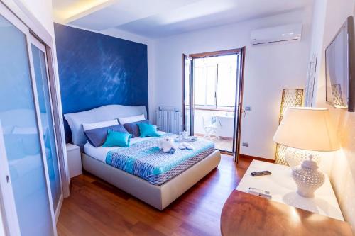 1 dormitorio con 1 cama con pared azul en B&B Tiffany, en Palinuro
