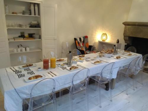 a white table with plates of food on it at Les Gîtes du Château de Passillé in Parigné