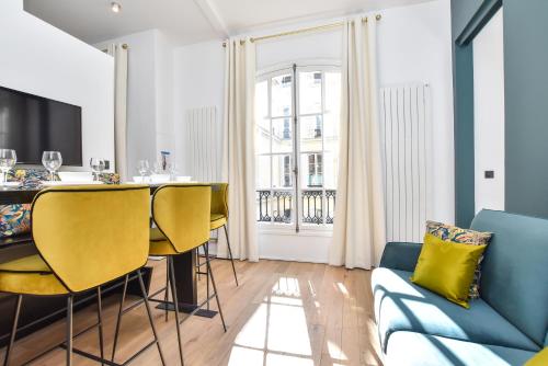 un salon avec une table et un canapé bleu dans l'établissement CMG Résidence Palais de l'Elysée Saint-Honoré, à Paris