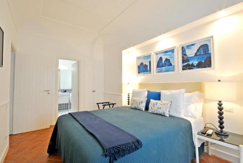 um quarto com uma cama grande e um cobertor azul em Carthusia Suites em Capri