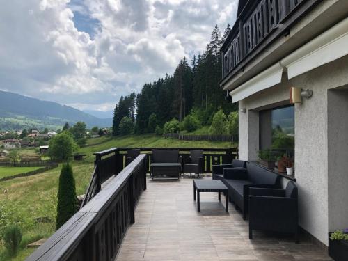 a patio with chairs and tables on a balcony at Bucovina Lodge Pension in Vama