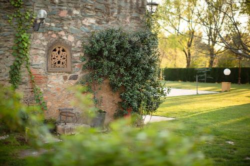 un edificio de piedra con ventana y banco en La Posada del Moro en Cazalla de la Sierra