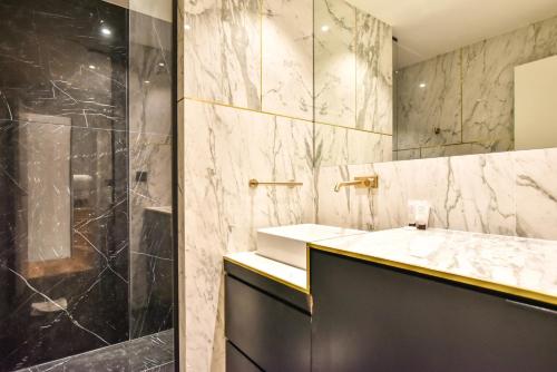 une salle de bain avec un lavabo et une douche dans l'établissement CMG Résidence Palais de l'Elysée Saint-Honoré, à Paris