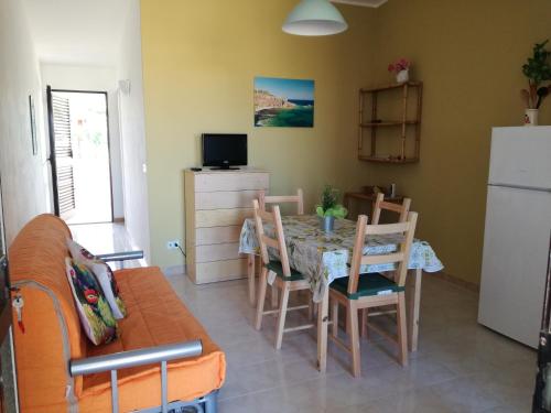 a kitchen and dining room with a table and chairs at Bilocale fronte spiaggia a Marzamemi in Marzamemi