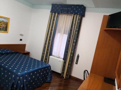 a bedroom with a blue bed and a window at Hotel La Cantina in Alfonsine