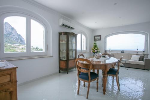 ein Wohnzimmer mit einem Tisch, Stühlen und einem Sofa in der Unterkunft Aldarogi in Capri