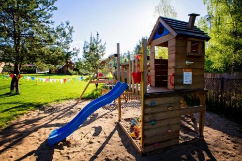 a playground with a slide and a play structure at Winiec Family Houses in Winiec