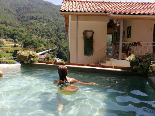 a woman in a pool of water in a house at Tea House Gerês - T1 Hipericão in Geres