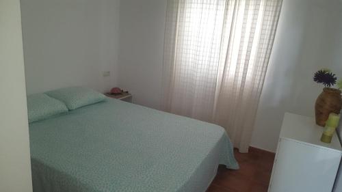 um pequeno quarto com uma cama e uma janela em Casas Baro2 em Zahora