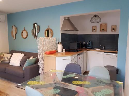 uma cozinha e uma sala de estar com uma mesa de vidro em Villa patio terrasse privative océan 10 min a pied em Seignosse