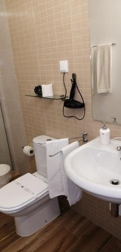 a bathroom with a white toilet and a sink at Nature Guesthouse in Lagos