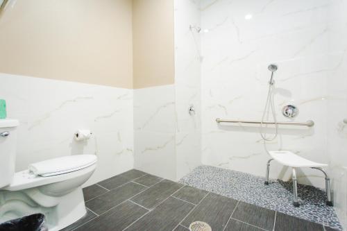 a white bathroom with a toilet and a shower at Budget Host Inn & Suites in Four Corners