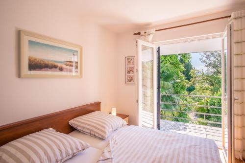 een slaapkamer met 2 bedden en een groot raam bij Nova Mira in Malinska