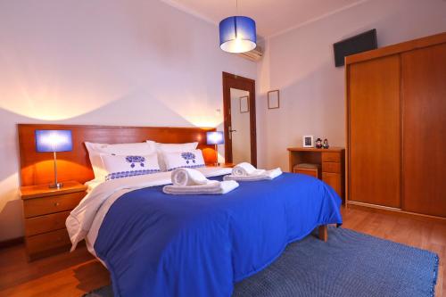 sypialnia z niebieskim łóżkiem i 2 ręcznikami w obiekcie Dolce Vianna - City Centre Rooms w mieście Viana do Castelo