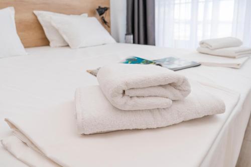 a pile of towels sitting on top of two beds at Aparthotel Primorsko in Primorsko