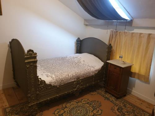ein Schlafzimmer mit einem antiken Bett und einem Waschbecken in der Unterkunft L'OBSIDIENNE in Lixheim