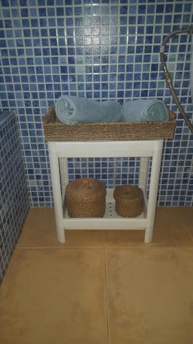 a blue tiled bathroom with two baskets and towels at Casas Baro2 in Zahora