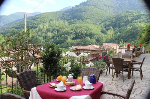 a table with food and drinks on a balcony with mountains at Posada Sobrevilla in Espinama