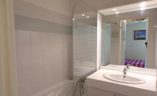 y baño blanco con lavabo y ducha. en La Foux d'Allos, en La Foux