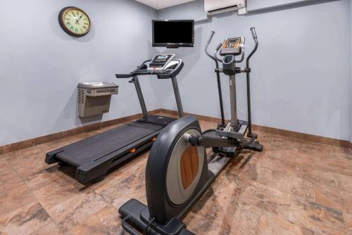 a gym with a treadmill and a clock on a wall at La Quinta by Wyndham Belgrade - Bozeman Airport in Belgrade