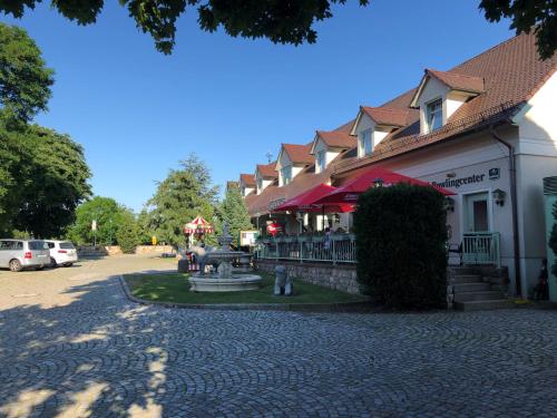 a building with a fountain next to a street at Pension Zur Linde in Berlstedt