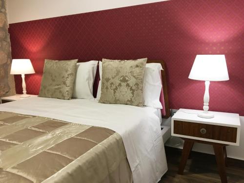 a bedroom with a bed and two lamps on tables at Apartamento da Seara "Lamego" in Lamego