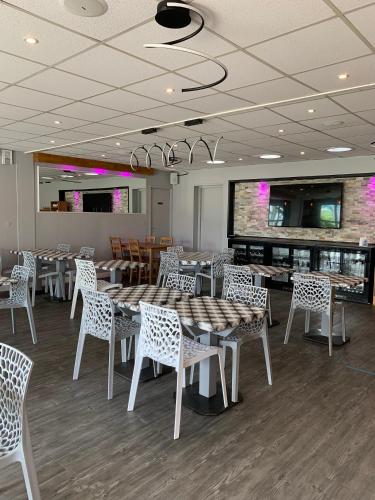 een eetkamer met tafels en witte stoelen bij Fasthotel Orleans Zénith in Orléans