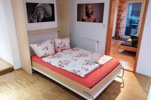 uma cama num quarto com duas fotografias na parede em Direkt im Herzen von Bayreuth Wohnung S9 mit 115qm und großem Balkon em Bayreuth