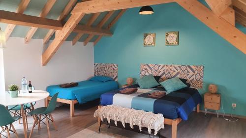 a bedroom with two beds and a table and a table and chairs at GO4SURF beach Lofts in Peniche