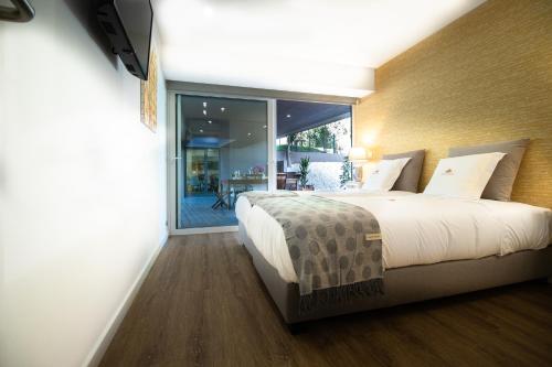 ein Schlafzimmer mit einem großen Bett und einem großen Fenster in der Unterkunft Sun House in Cabedelo in Viana do Castelo