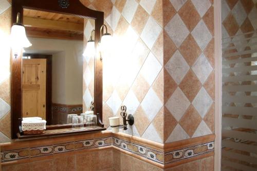 a bathroom with a mirror and a sink at Molino Cuatro Paradas in Benaoján