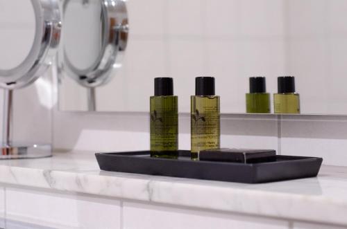 four bottles of moisturizers sitting on a counter in a bathroom at Hotel am Feldmarksee in Sassenberg