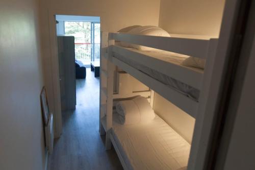Ce dortoir comprend 2 lits superposés et une porte ouverte. dans l'établissement Princess of Bel Air avec garage privé et tennis - 300m plage et commerces, à Pornichet