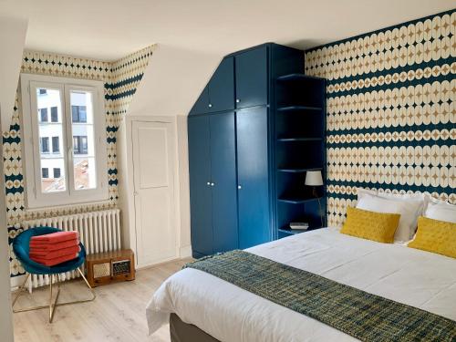 ein Schlafzimmer mit einem großen Bett und einem blauen Schrank in der Unterkunft La Villégiature et la Maisonnette in Vichy