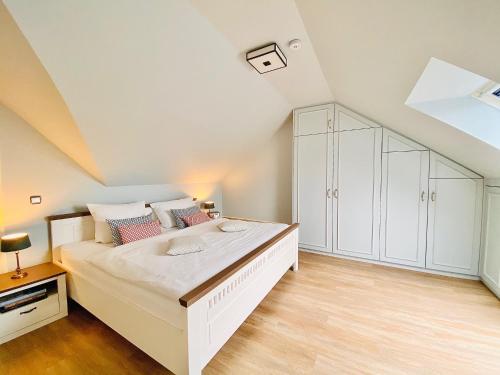 ein weißes Schlafzimmer mit einem großen Bett und einem weißen Schrank in der Unterkunft Ferienwohnung Carlotta in der Villa Seeblick in Bad Saarow