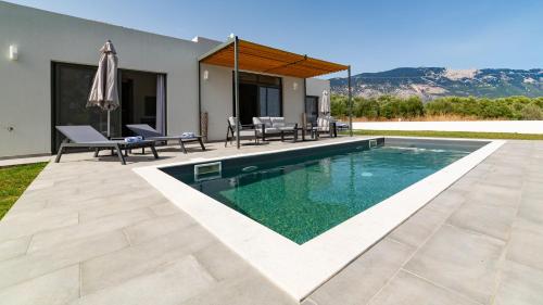 a swimming pool in the backyard of a house at Villa Esther in Kefallonia