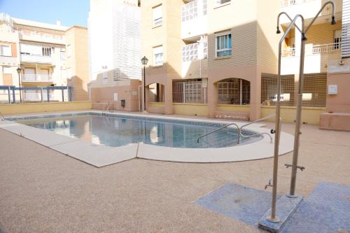 a swimming pool in the middle of a building at AMPLIO APTO en ROQUETAS in Roquetas de Mar