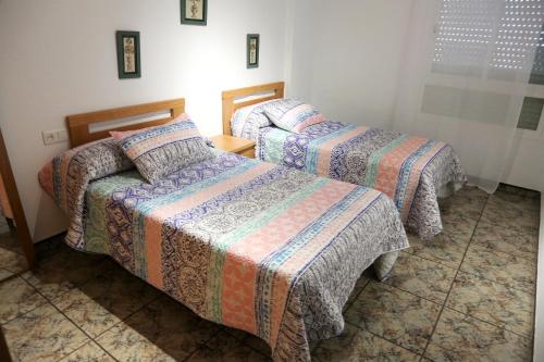 two beds in a hotel room with two beds sidx sidx sidx at AMPLIO APTO en ROQUETAS in Roquetas de Mar