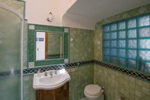 y baño con lavabo y aseo. en Appartamento immerso nel verde en Capri