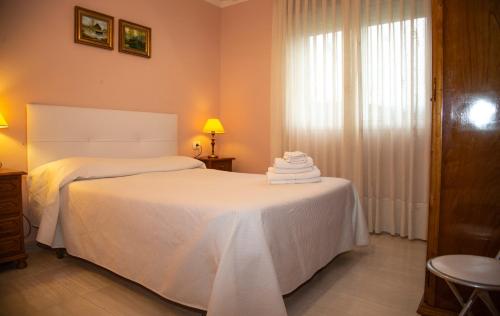 una camera da letto con un letto con lenzuola bianche e una finestra di Pico da Costa a Barreiros