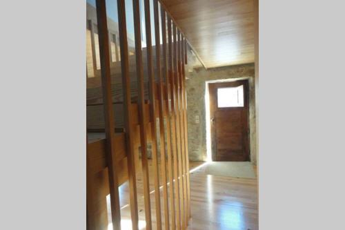 a room with a wooden staircase and a door at Casa do Palheiro in Miranda do Douro