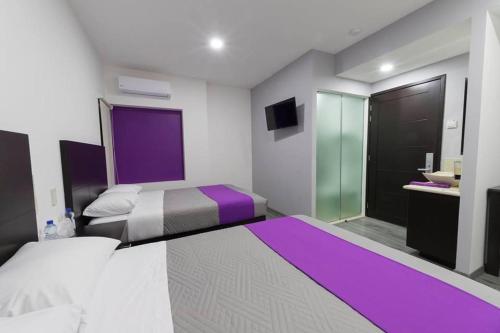 a bedroom with two beds and a bathroom with a sink at La Terraza Hotel in Jalpan