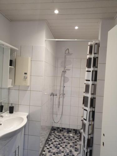 ein weißes Bad mit einer Dusche und einem Waschbecken in der Unterkunft Casa Künske in Halle Westfalen