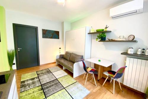 a living room with a couch and a table and chairs at Spa Tiny Love Apartment close to Milan-Como-Malpensa in Saronno